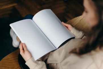 person holding a book with blank pages